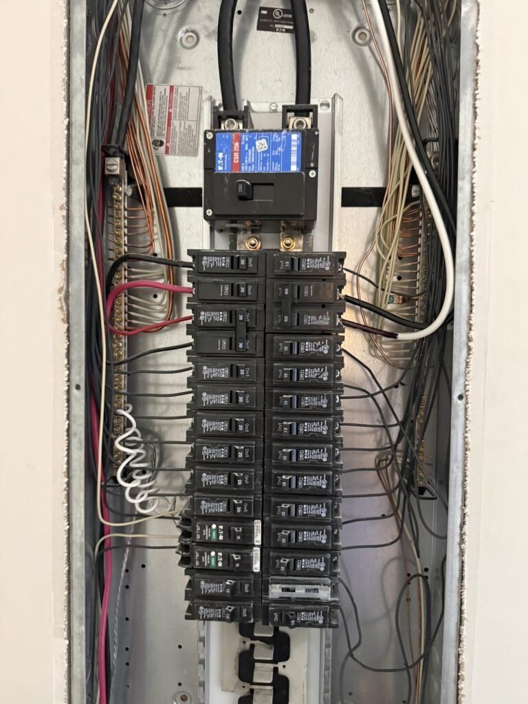Open electrical panel showing loaded breakers during an inspection by S&H Contracting